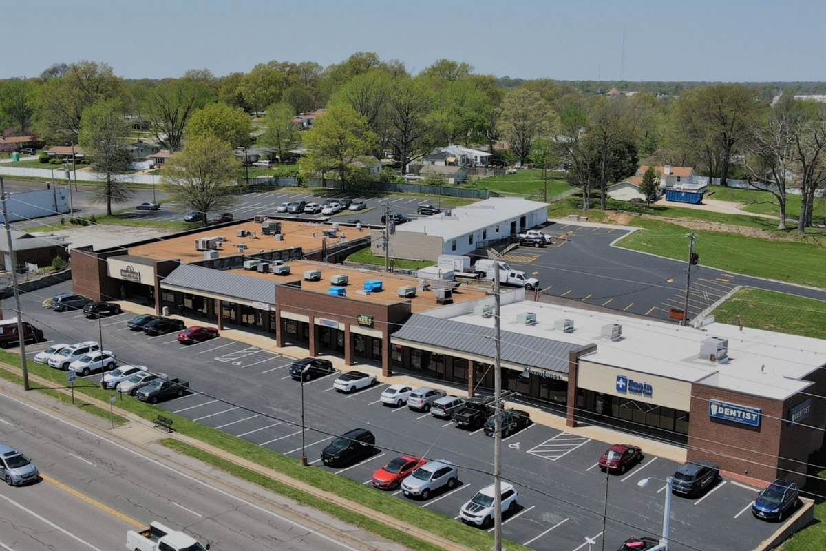 aerial view of shopping center with cars parked in front