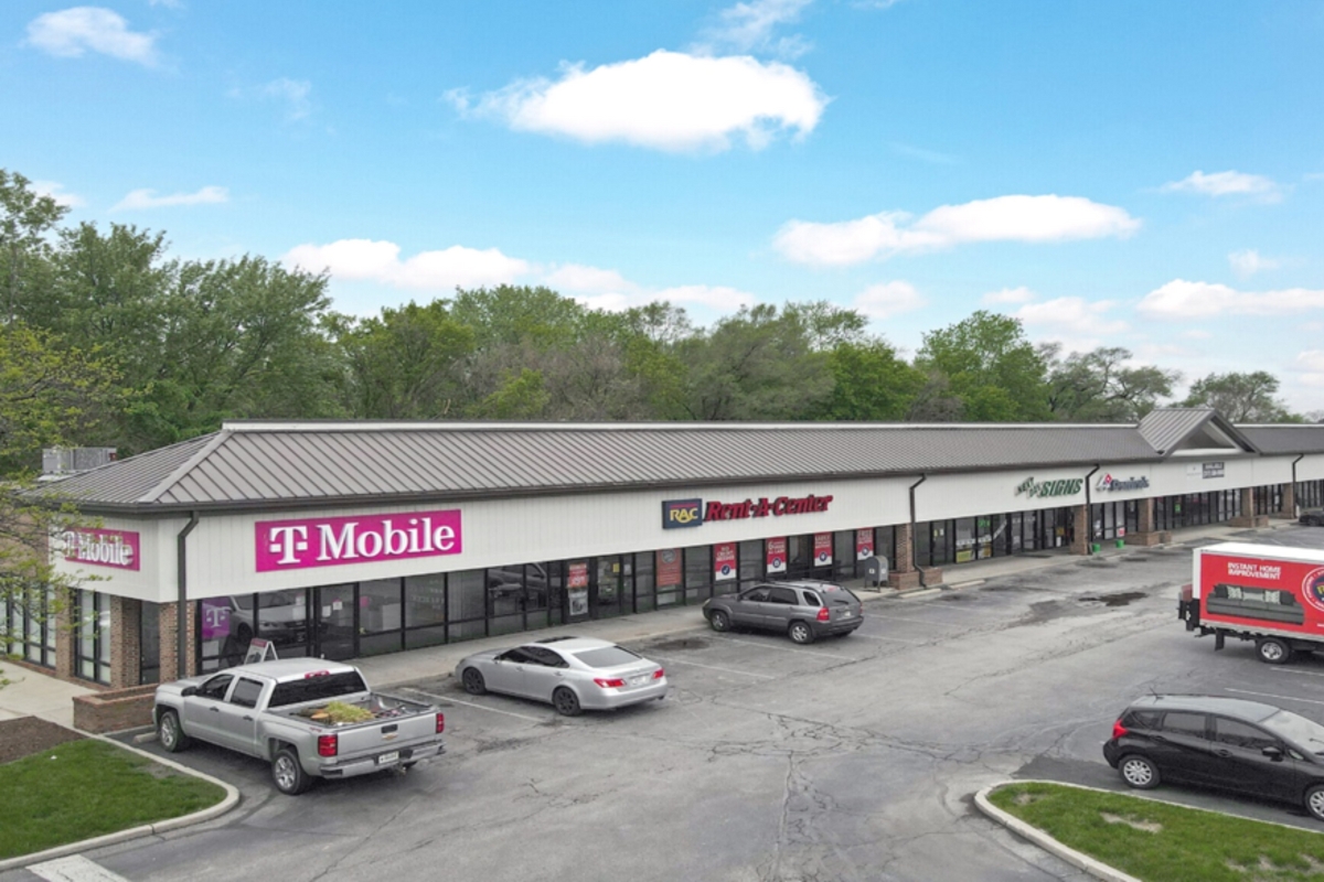 aerial view of shopping center with some cars parked in front